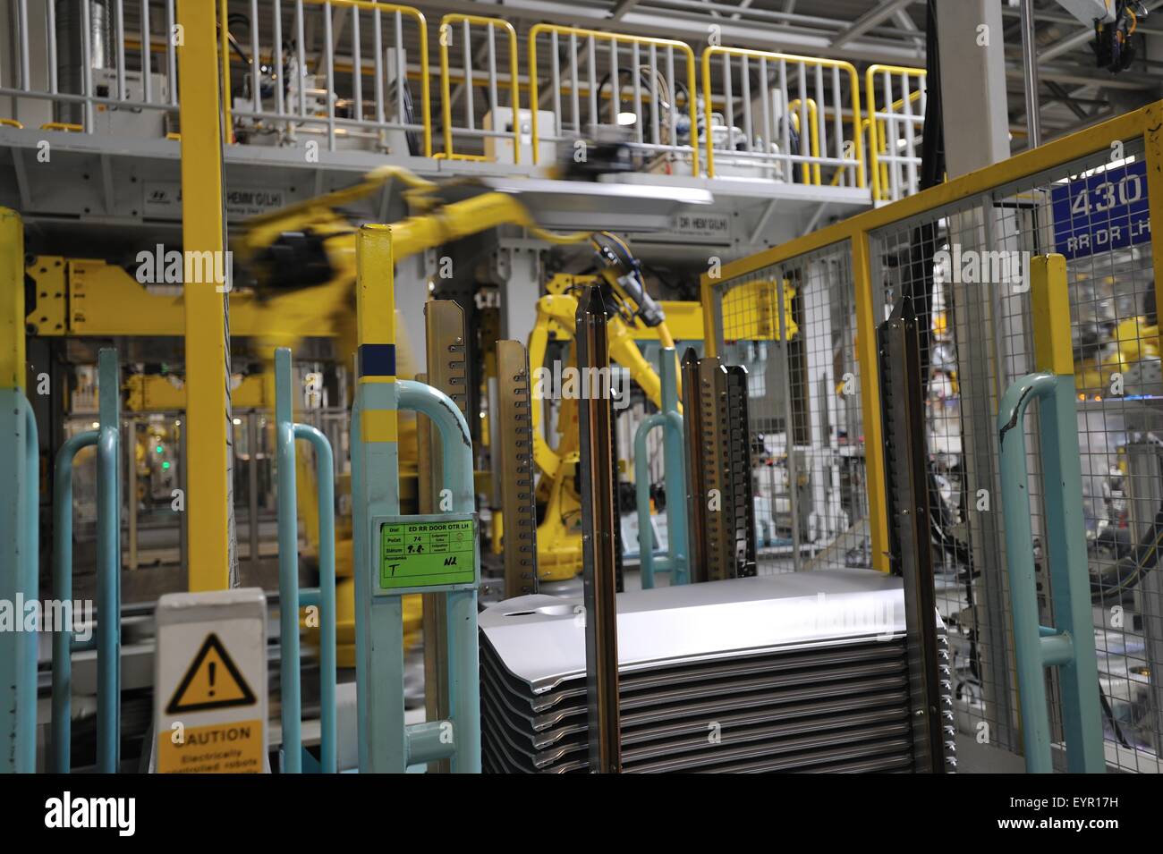 All'interno di una moderna fabbrica di automobili e veicoli e parti si muovono attraverso il processo di produzione, il robot di prelievo dei pannelli del corpo Foto Stock