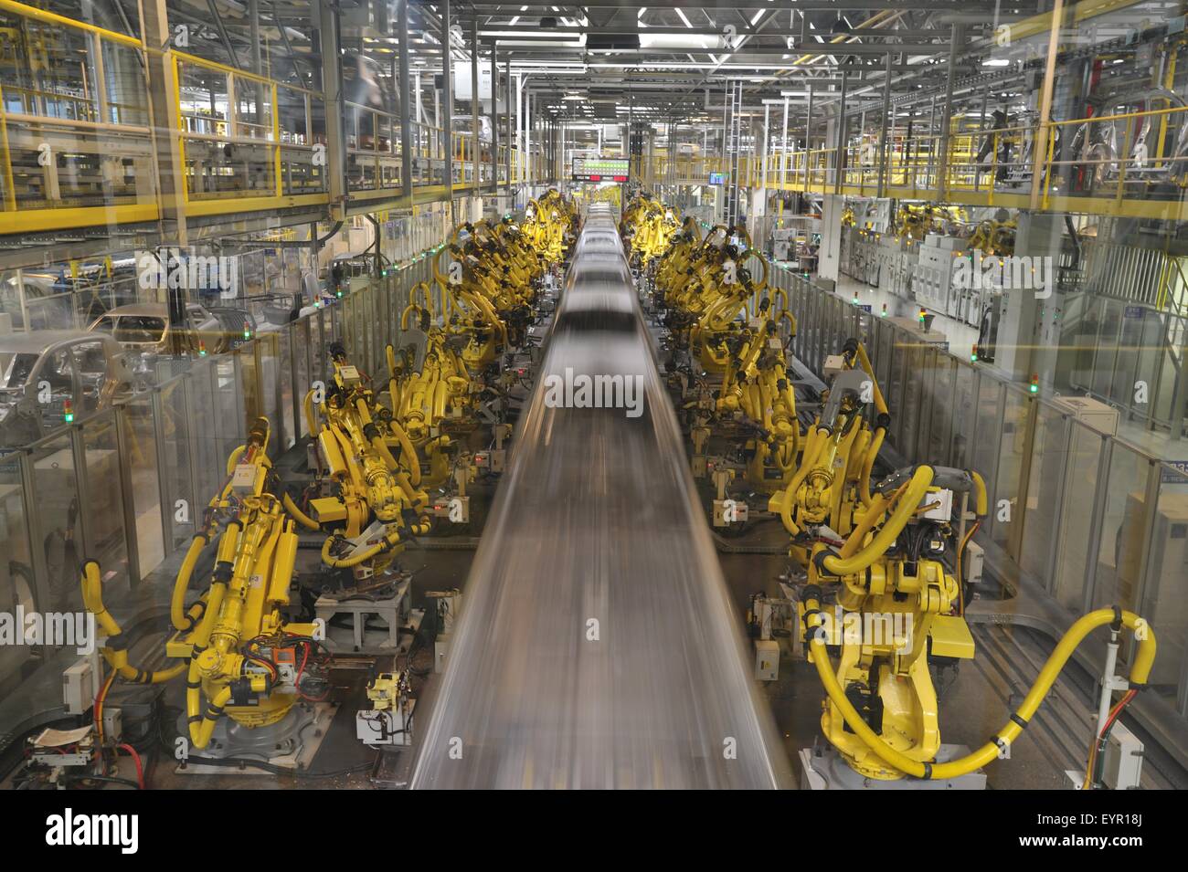 All'interno di una moderna fabbrica di automobili e veicoli e parti si muovono attraverso il processo di produzione, robot e gusci di auto le sfocature Foto Stock