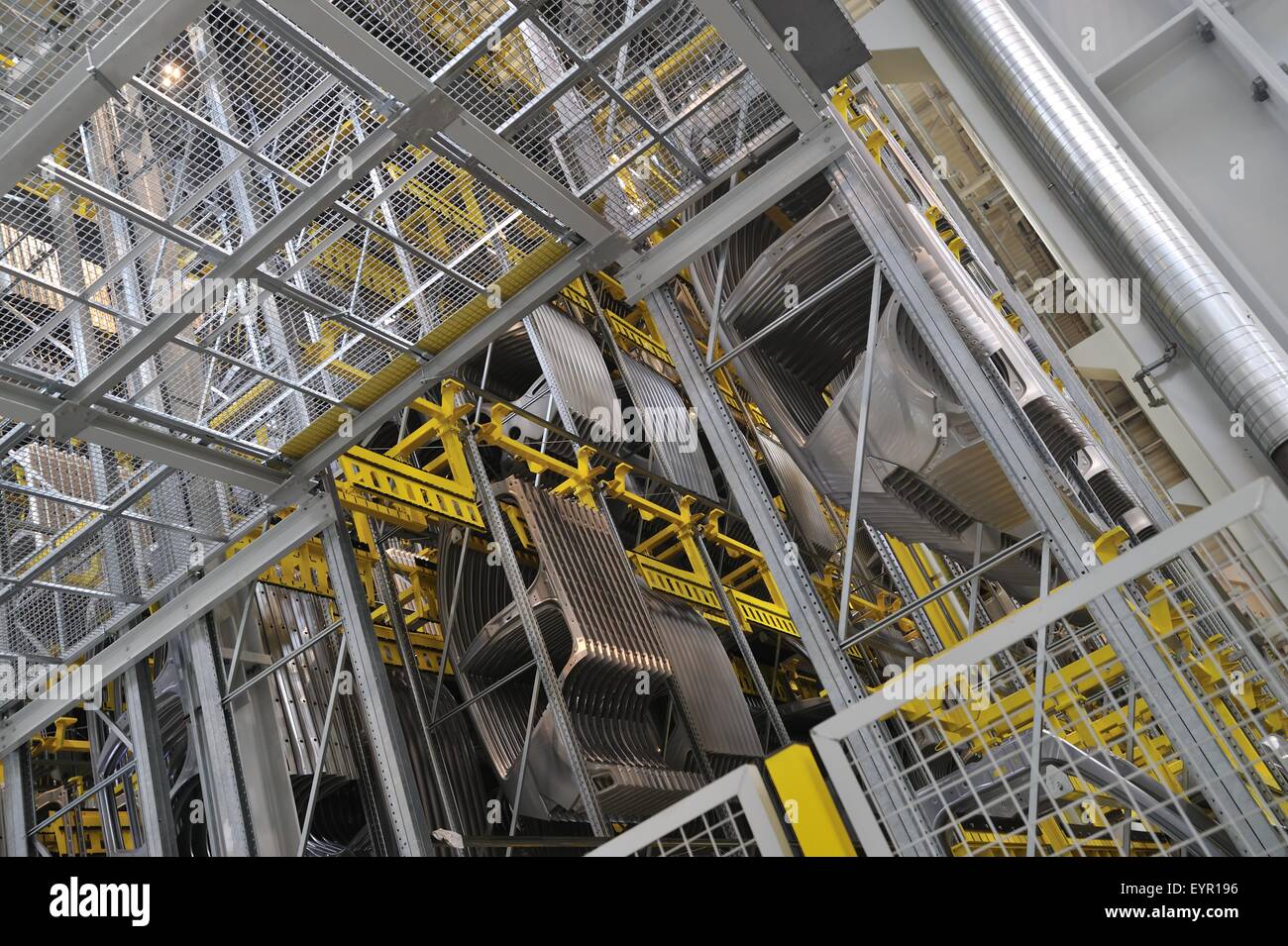 All'interno di una moderna fabbrica di automobili e veicoli e parti si muovono attraverso il processo di produzione, auto i lati appendere in rack di stoccaggio Foto Stock