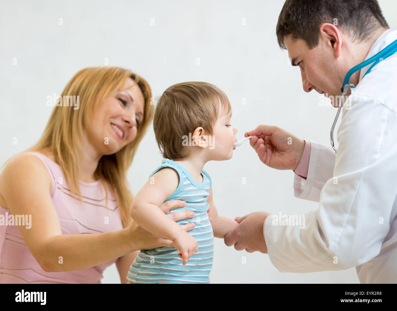 Medico dando un cucchiaio di sciroppo al bambino Foto Stock