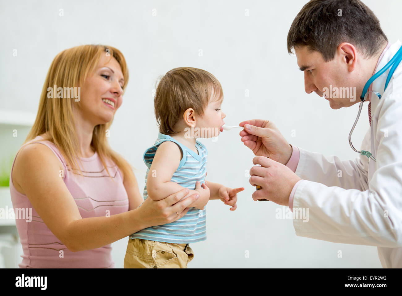 Medico dando un cucchiaio di sciroppo al bambino Foto Stock