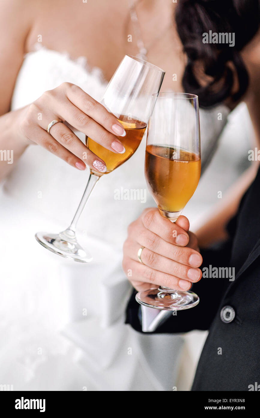 Le mani della sposa e lo sposo con bicchieri di champagne Foto Stock