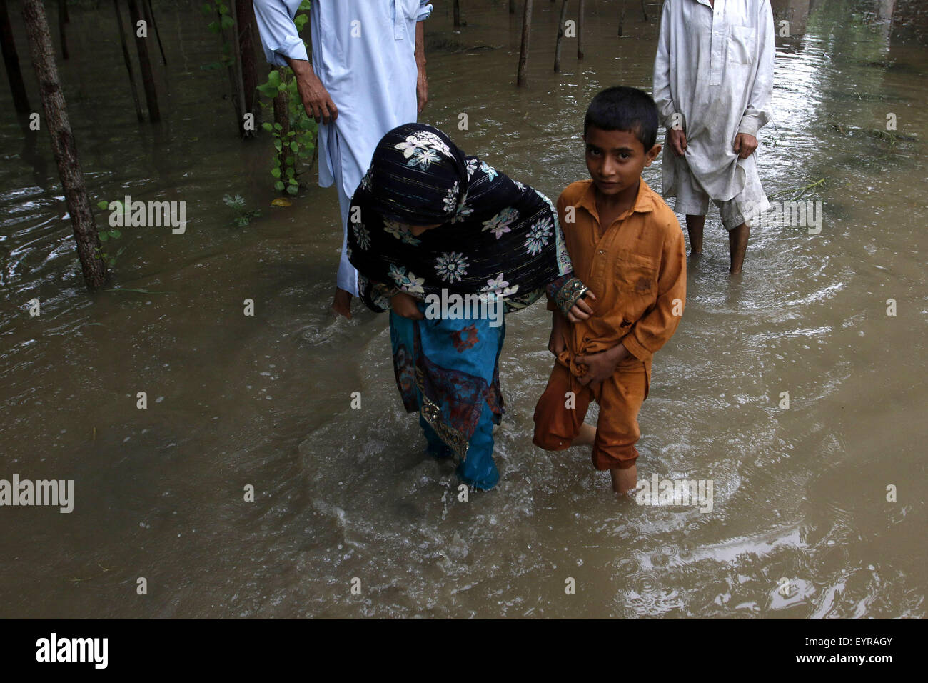 A Peshawar, Pakistan. Il 3° agosto 2015. Pakistani wade attraverso inondazione nella periferia della città di Peshawar, a nord-ovest del Pakistan, il 3 agosto, 2015. Credito: Umar Qayyum/Xinhua/Alamy Live News Foto Stock