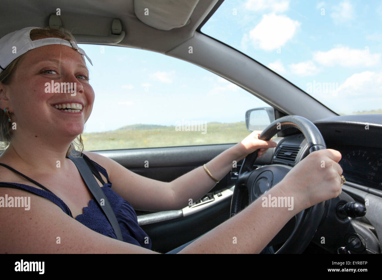 Giovane donna aziona un auto come visto dal sedile del passeggero modello di rilascio disponibili Foto Stock