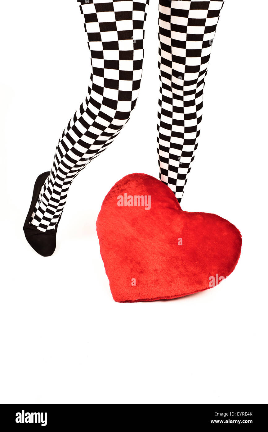 Le gambe di una donna in ginocchio a scacchi alto calzini e un cuore rosso Cuscino sagomato Foto Stock