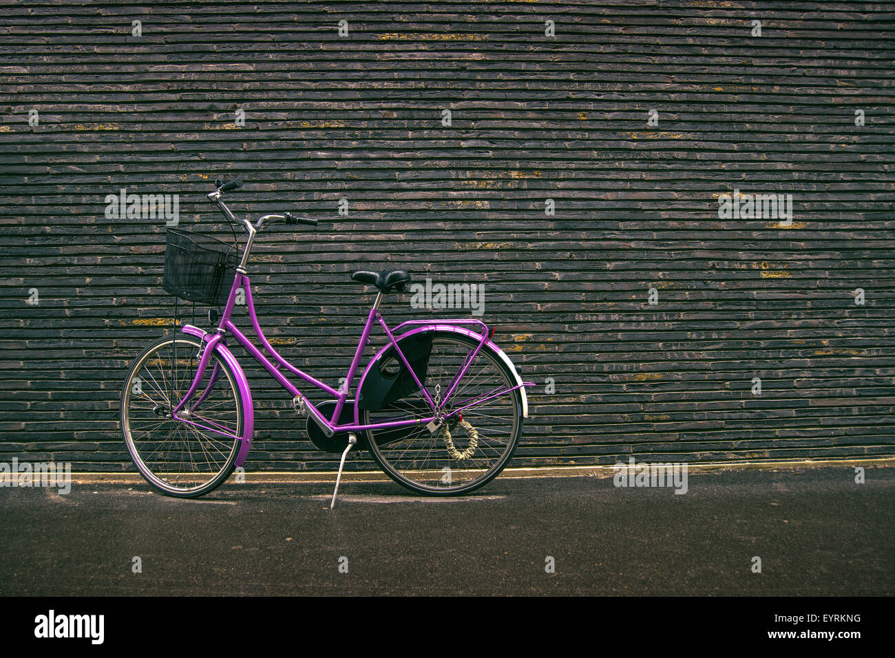 Classic Vintage Tanga viola bicicletta su strada appoggiata contro il muro di mattoni, dai toni rétro immagine Foto Stock