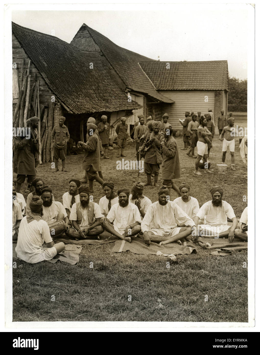 Fotografia di soldati sikh che cantano canti religiosi al di fuori delle loro billette a le Sart, in Francia, probabilmente durante la prima guerra mondiale, mostrando pratiche culturali in un contesto militare. Foto Stock