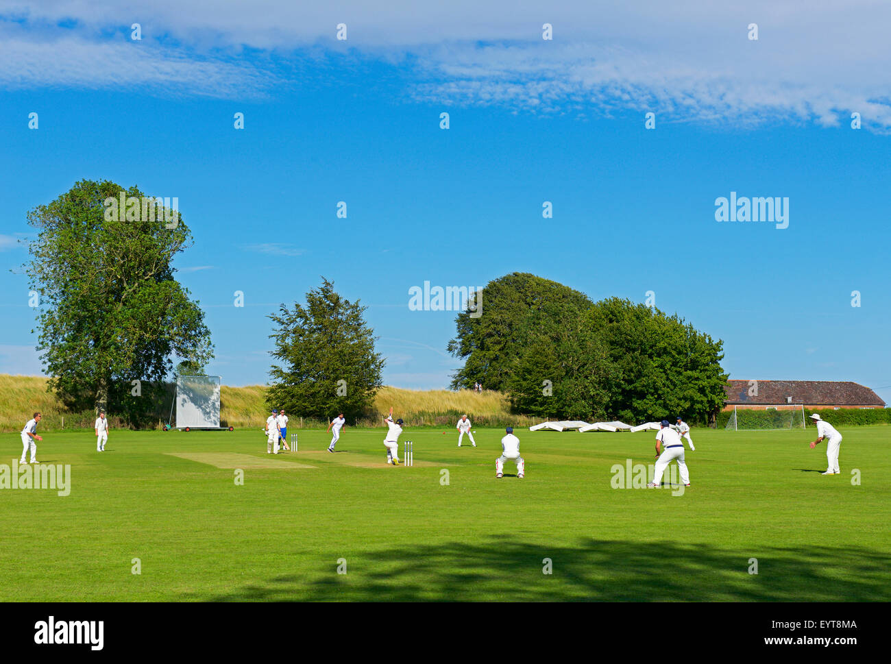 Gioco di cricket essendo giocato ad Avebury, Wiltshire, Inghilterra, Regno Unito Foto Stock