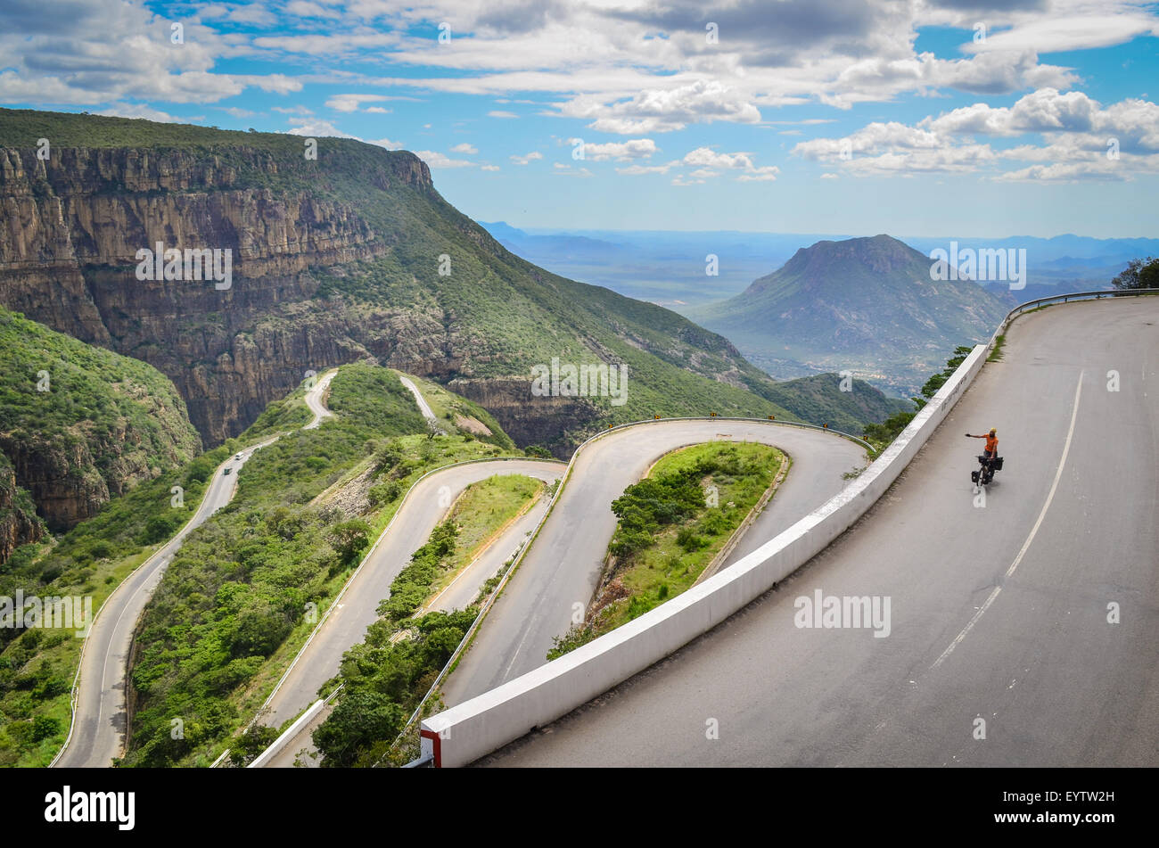 Ciclista sulla Serra da Leba, una catena montuosa in Angola con le impressionanti Leba strada di montagna e i suoi tornanti Foto Stock