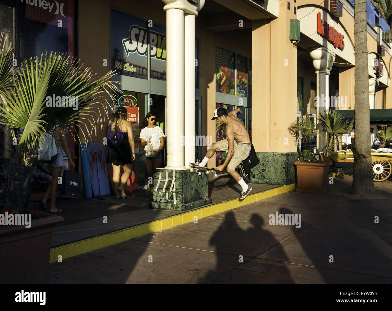 Huntington Beach, CA, Stati Uniti d'America. 1 agosto, 2015. Agosto 1, 2015 - Huntington Beach, California, Stati Uniti - Bryan Torrellas, 23, da Hermosa Beach, CA, macina un cordolo di fronte a negozi e i passanti, vicino alla strada principale e Pacific Coast Highway. La copertura della cultura che è attratta verso il 2015 furgoni US Open di surf. Immagine di credito: Sean DuFrene/ZUMAPRESS.com © Sean Dufrene/ZUMA filo/Alamy Live News Foto Stock
