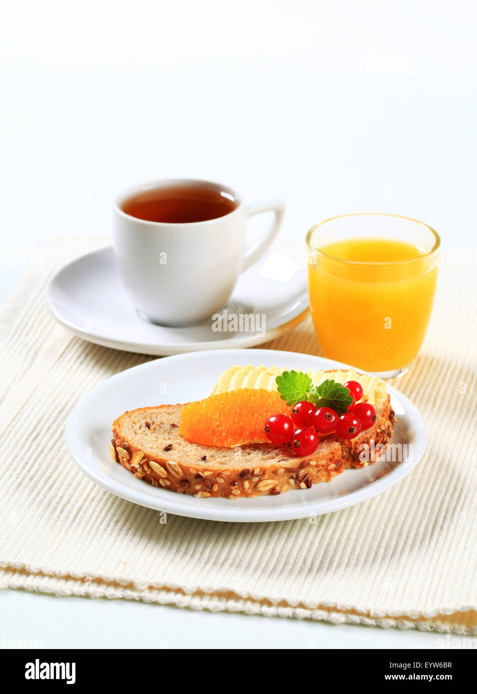 Pane con burro e frutta, tazza di tè e caffè e succo d'arancia Foto Stock