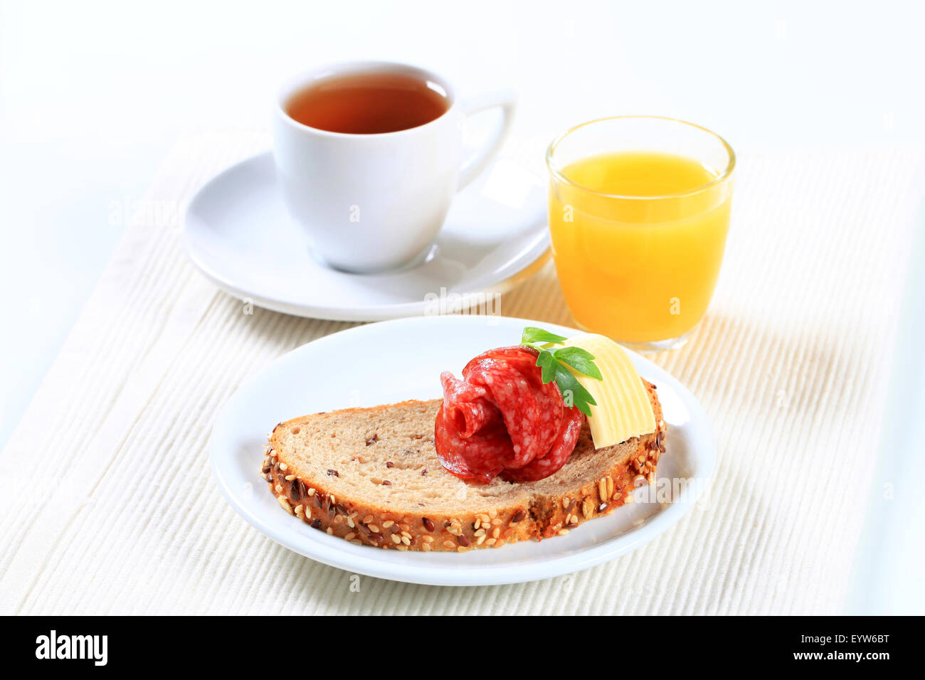 Pane con salame, tazza di tè e caffè e succo d'arancia Foto Stock
