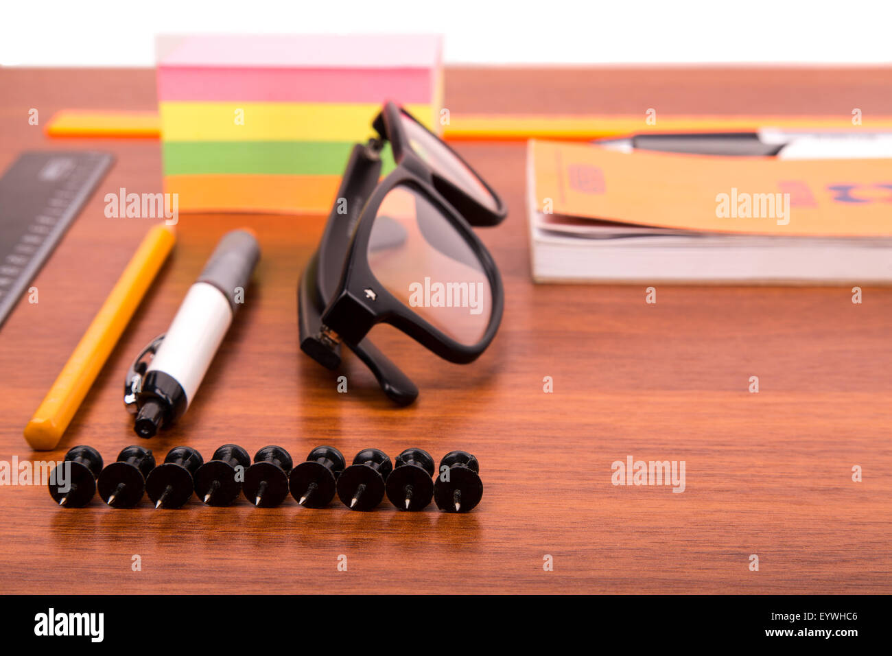 Scrivania da ufficio con gli occhiali penna matita righello e altri articoli per ufficio Foto Stock