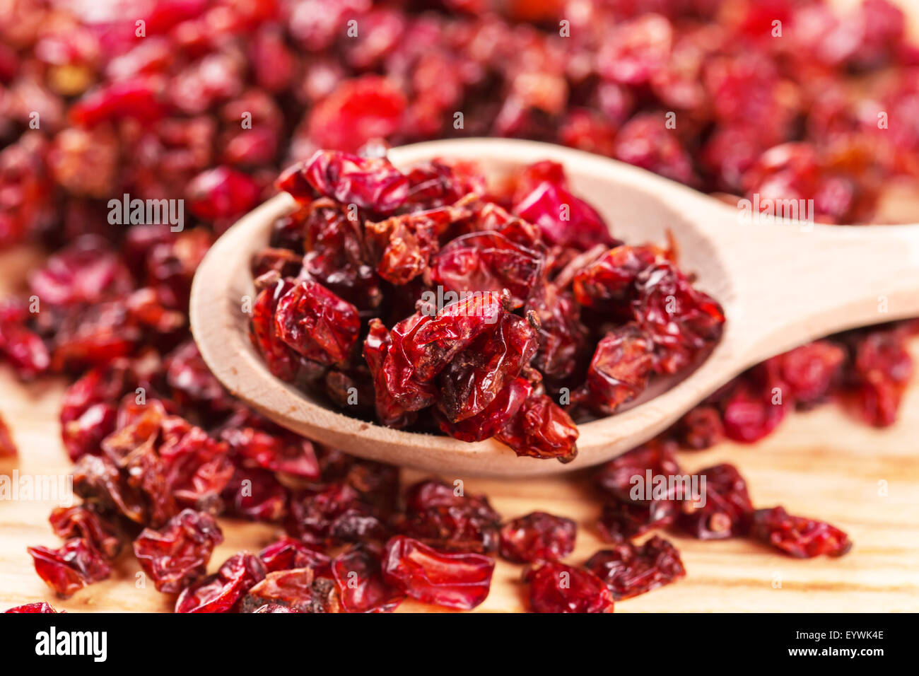 Rosso secco crespino spezie in i cucchiai di legno Foto Stock