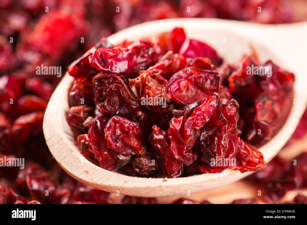 Rosso secco crespino spezie in i cucchiai di legno Foto Stock