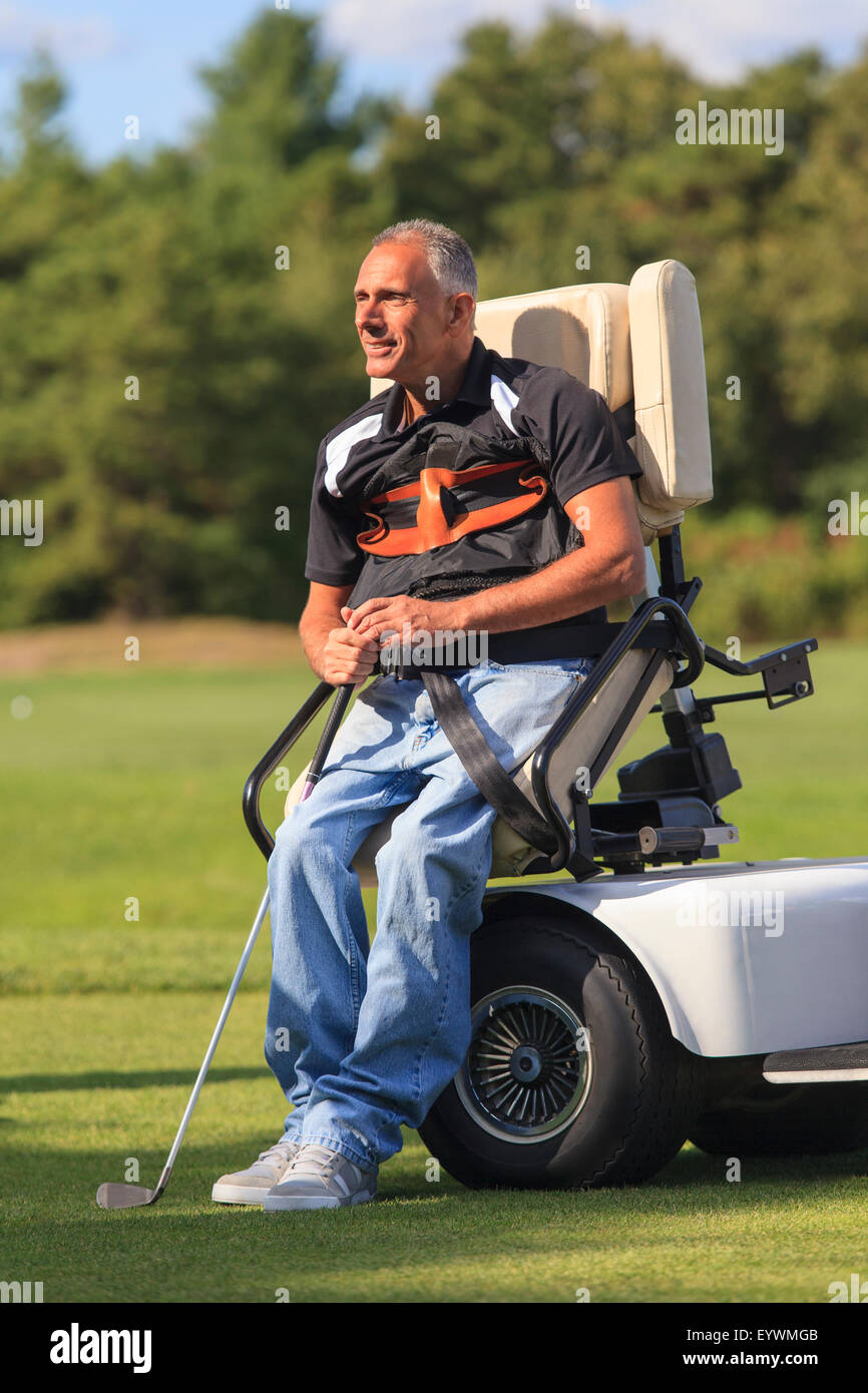 Uomo con una lesione del midollo spinale in un carrello adattativo circa per giocare a golf Foto Stock