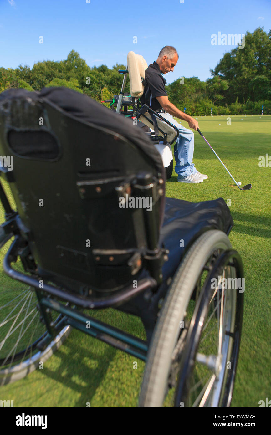 Uomo con una lesione del midollo spinale in un carrello adattabile a golf putting green Foto Stock