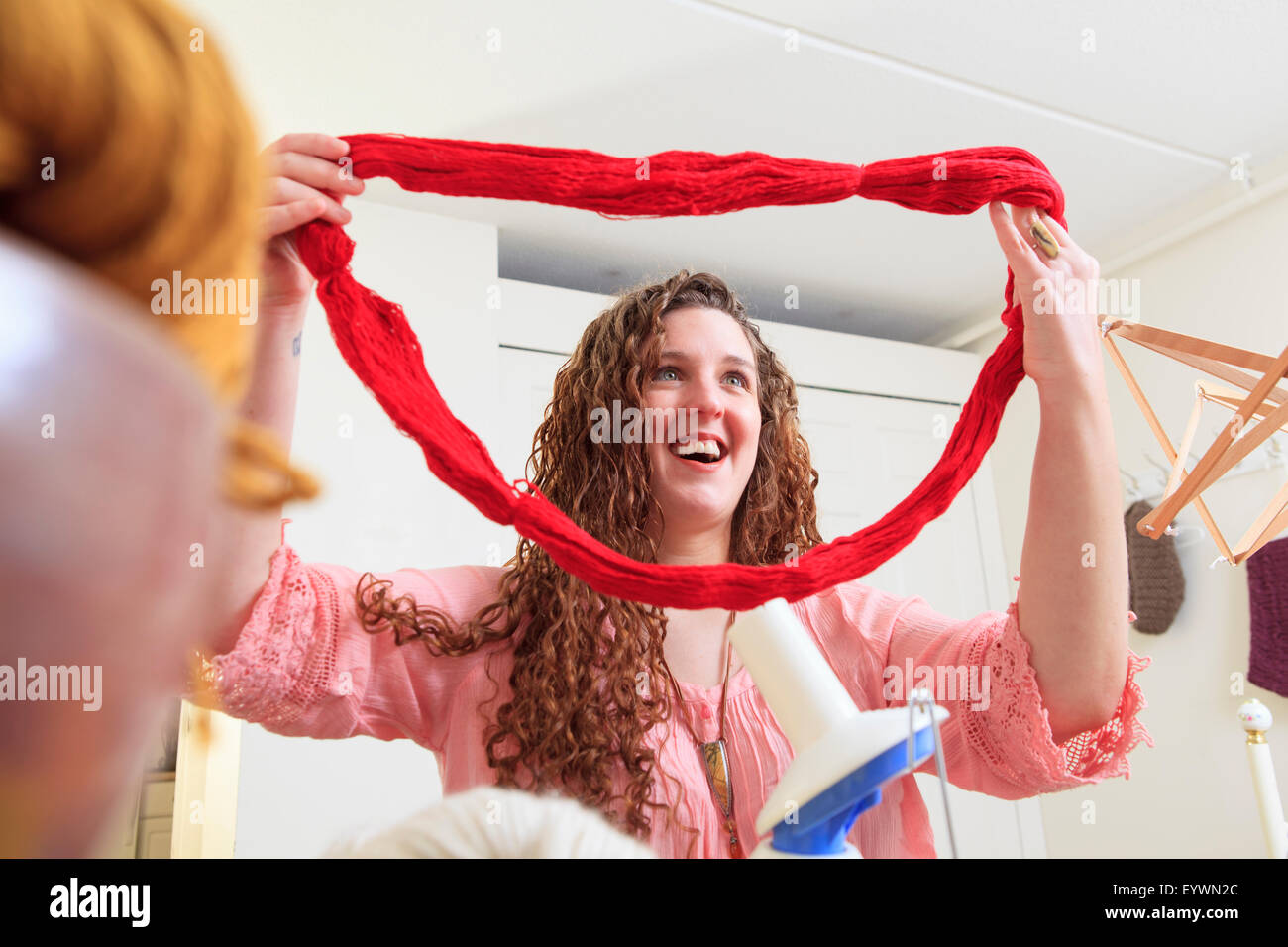 Donna con la distrofia muscolare a lavorare con il suo filo per la sua attività di lavorazione a maglia Foto Stock