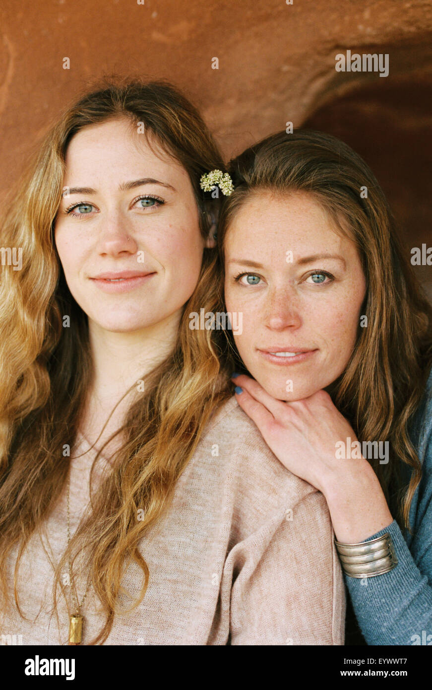 Due donne fianco a fianco, sorridente alla fotocamera. Foto Stock