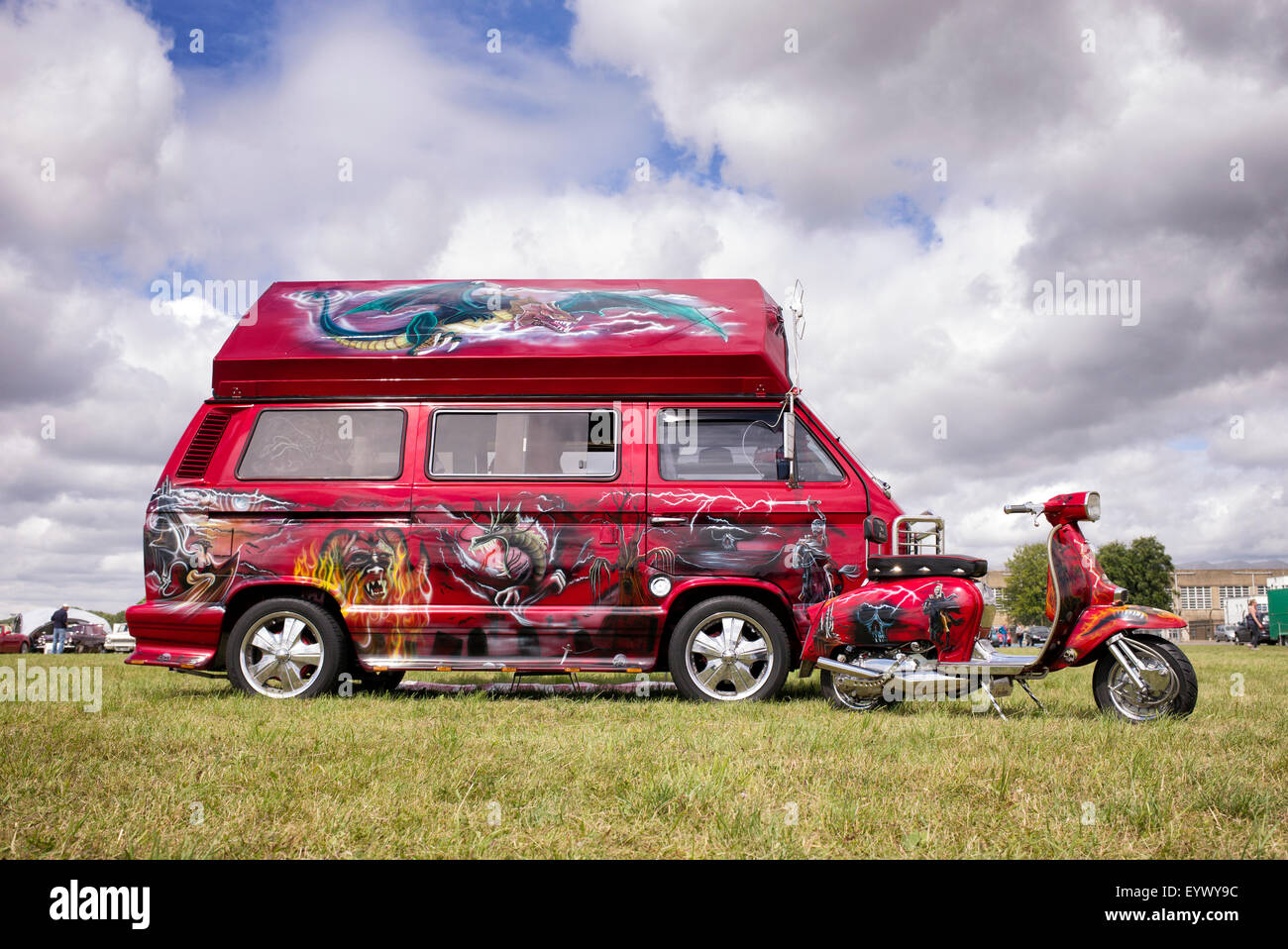 Custom fantasy dragon dipinti disegni su una VW Camper e scooter a una mostra di trasporto. Inghilterra Foto Stock