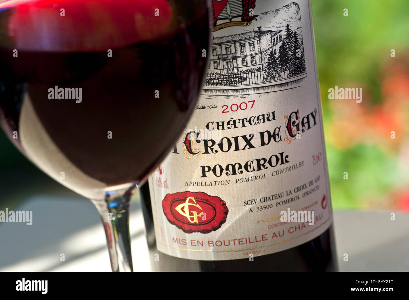 Chateau La Croix de Gay Pomerol 2007 bottiglie di vino e un bicchiere di ottimo Pomerol di lusso in alfresco degustazione vino situazione sulla terrazza con giardino tavolo Bordeaux Foto Stock