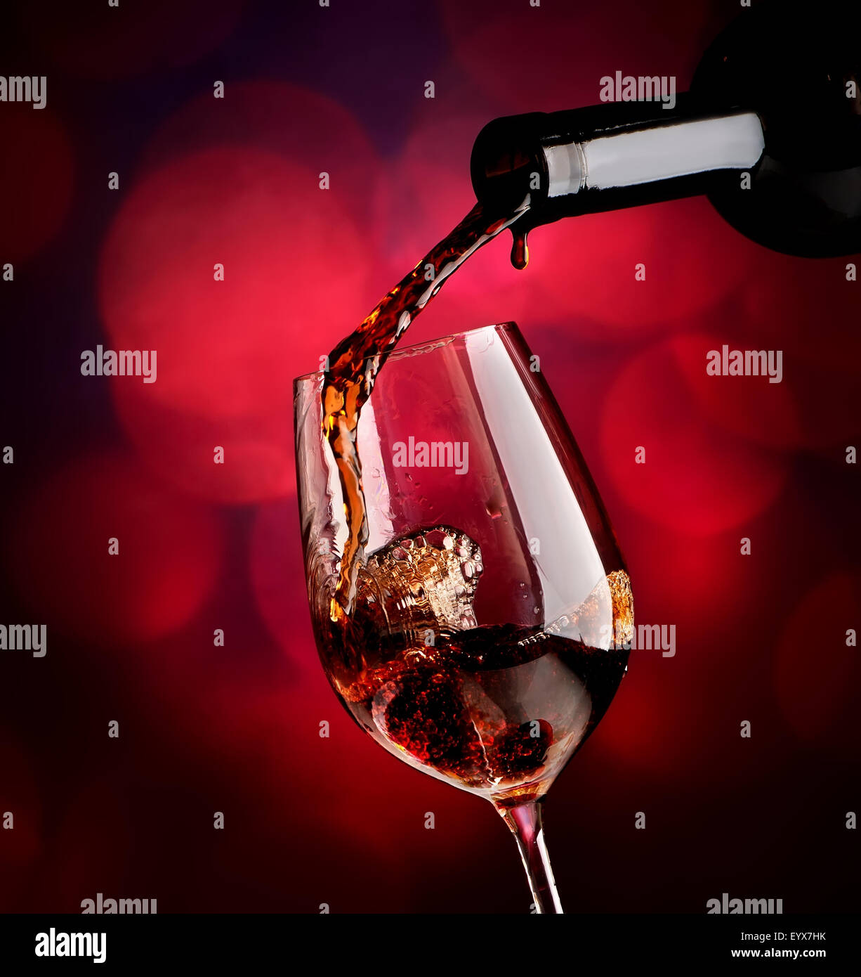 Versare il vino nella Wineglass su un sfondo vinosa Foto Stock