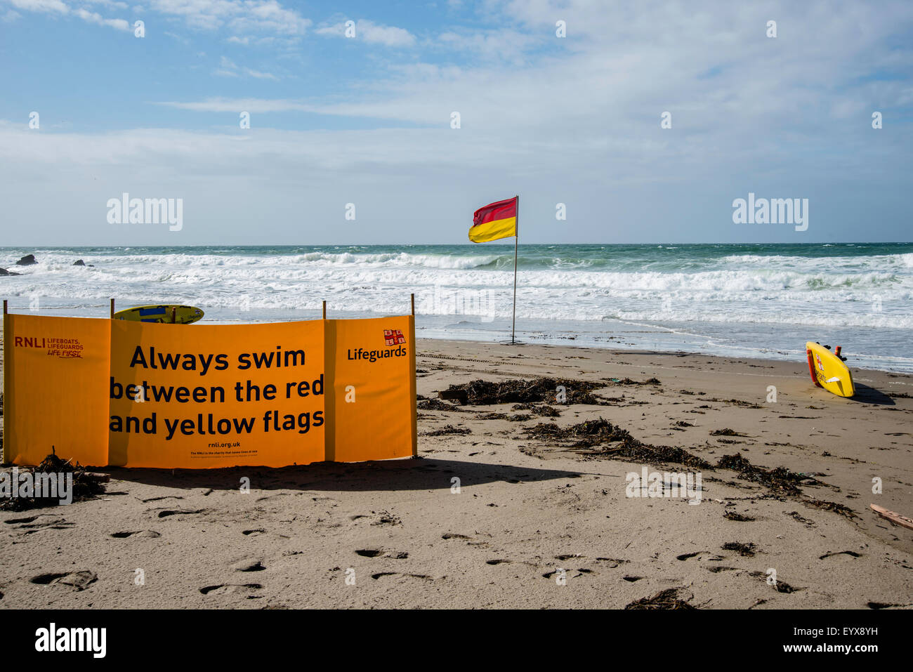 Surf lifesaving, flag di avviso e le attrezzature sulla spiaggia pronto per l'uso dai bagnini RNLI Foto Stock