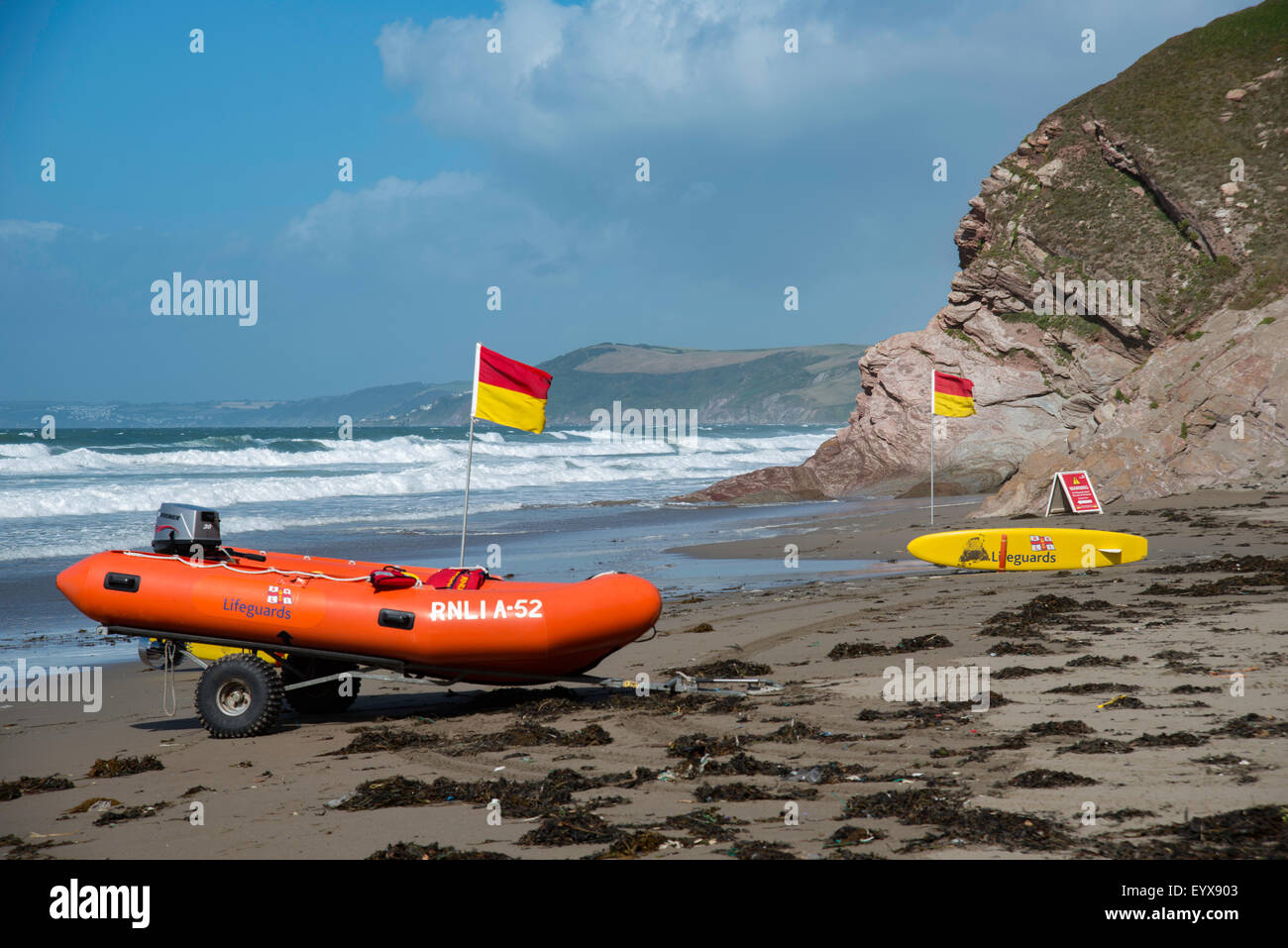 Surf lifesaving, flag di avviso e le attrezzature sulla spiaggia pronto per l'uso dai bagnini RNLI Foto Stock