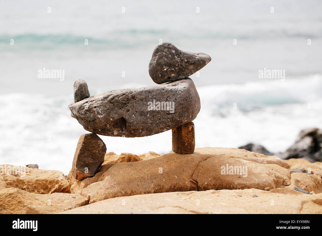 Un mucchio di ciottoli equilibrata nella forma di un cane Foto Stock