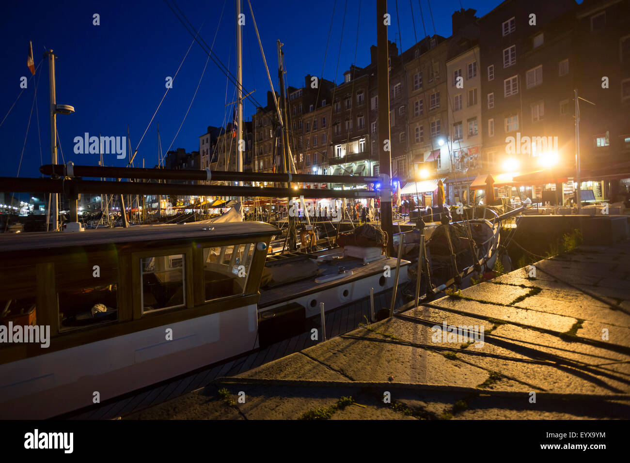 FRA, Frankreich, Normandie, Calvados, 30. Juli 2015: Ein Segelboot liegt Zur Blauen Stunde im Abendlicht im Alten Hafen vor der Foto Stock