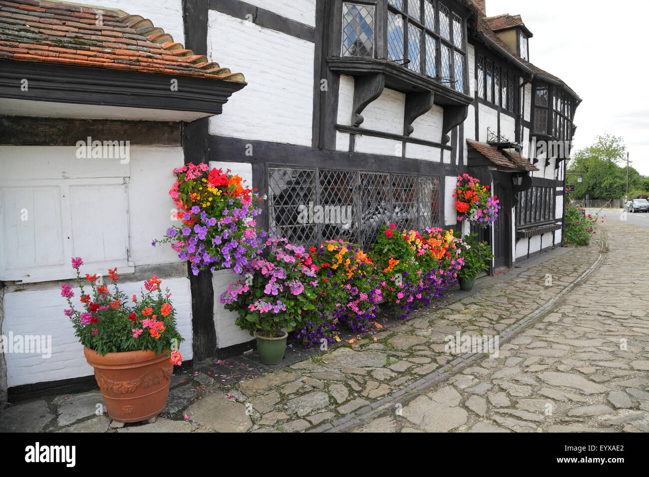 Finestre colorate che circondano la finestra di reticolo di tessitori medievali 'cottage a Biddenden, Kent, Regno Unito. Finestre a piombo con pannelli diamantati. Foto Stock