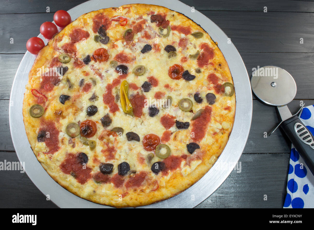 Tutta la pizza vegetariana con pomodoro ciliegino sul tavolo scuro Foto Stock