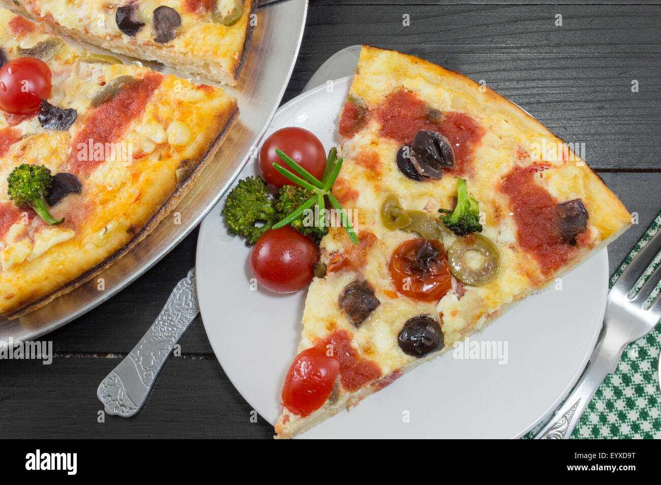 Pizza vegetariana fetta servita con pomodoro ciliegino e i broccoli. Pasto vegetariano. Foto Stock