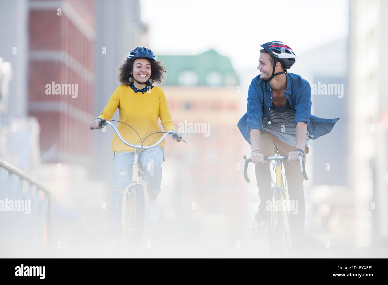 Coppia giovane di andare in bicicletta in città Foto Stock