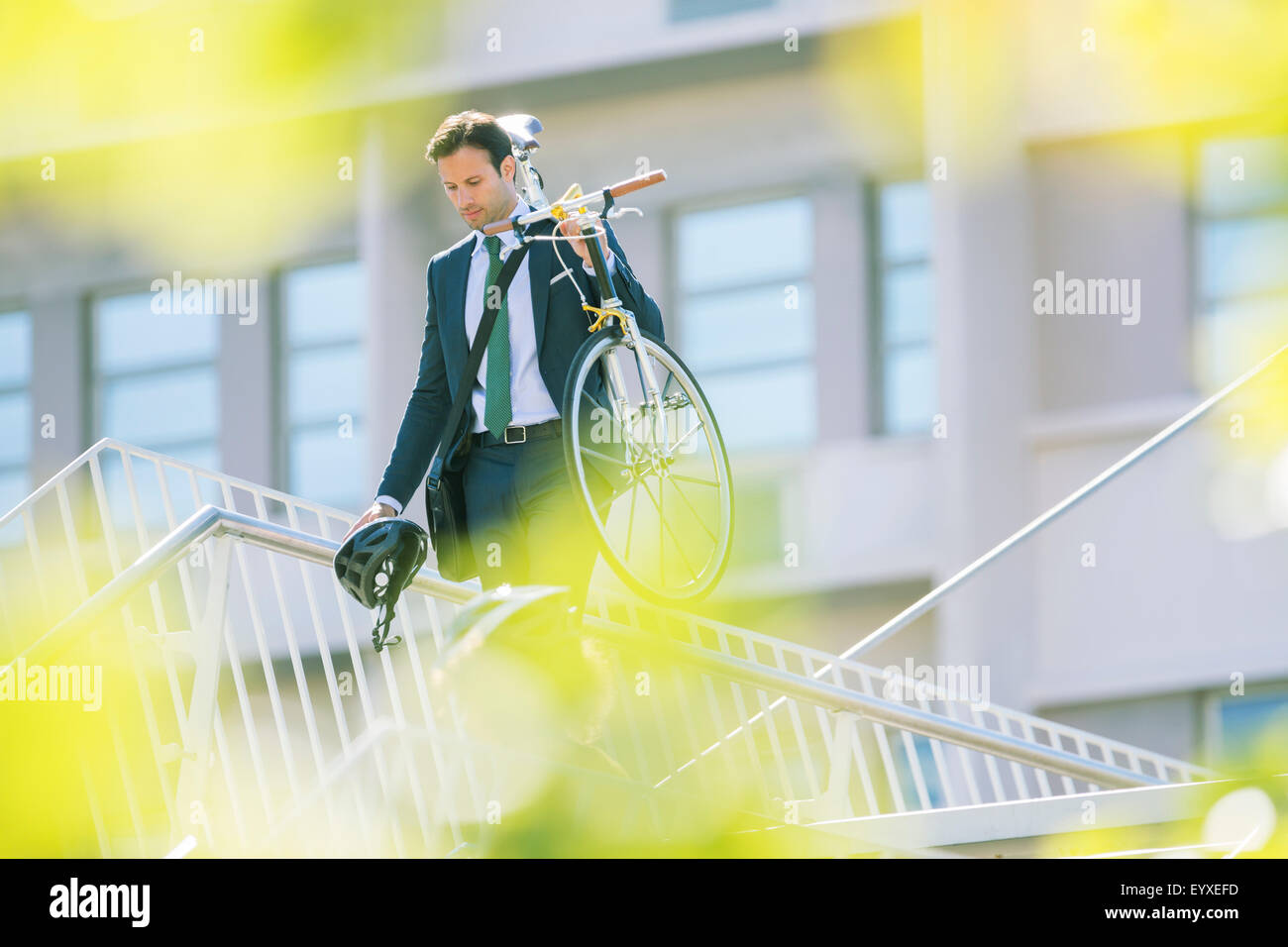 Imprenditore della tuta che trasportano in bicicletta in città Foto Stock