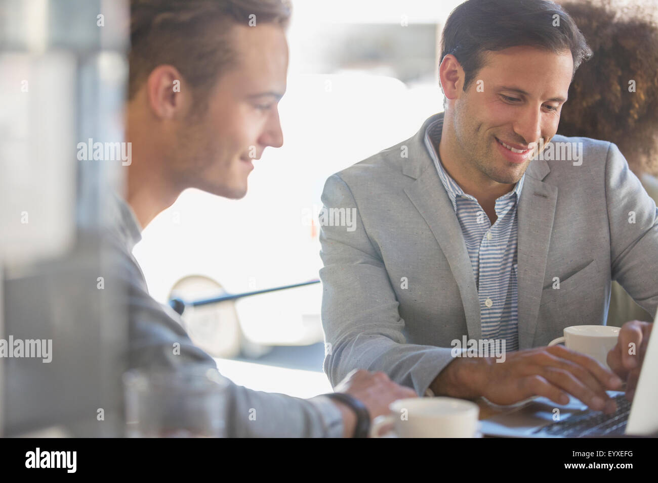 Imprenditori con caffè lavora al computer portatile in cafe Foto Stock
