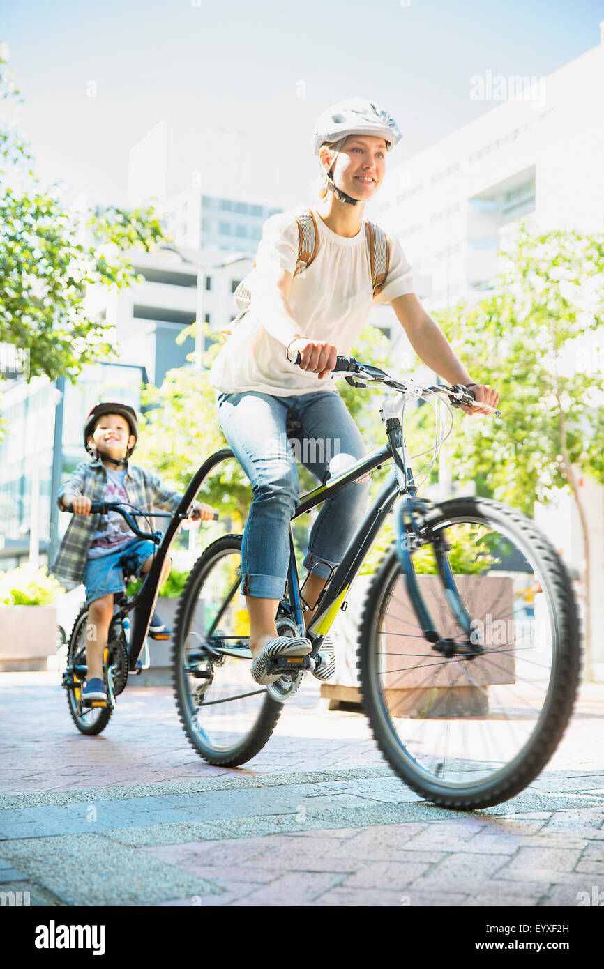 Madre e figlio di andare in bicicletta sul percorso urbano Foto Stock