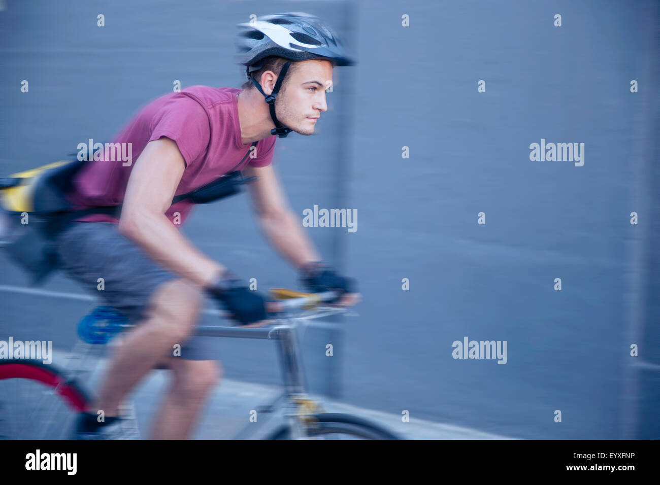 Bicicletta focalizzato messenger con casco in movimento Foto Stock
