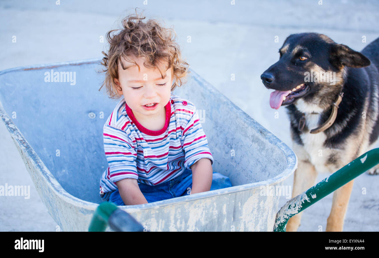 Ritratto di 1 anno di età bambino gioca con una ruota di Barrow. Foto Stock