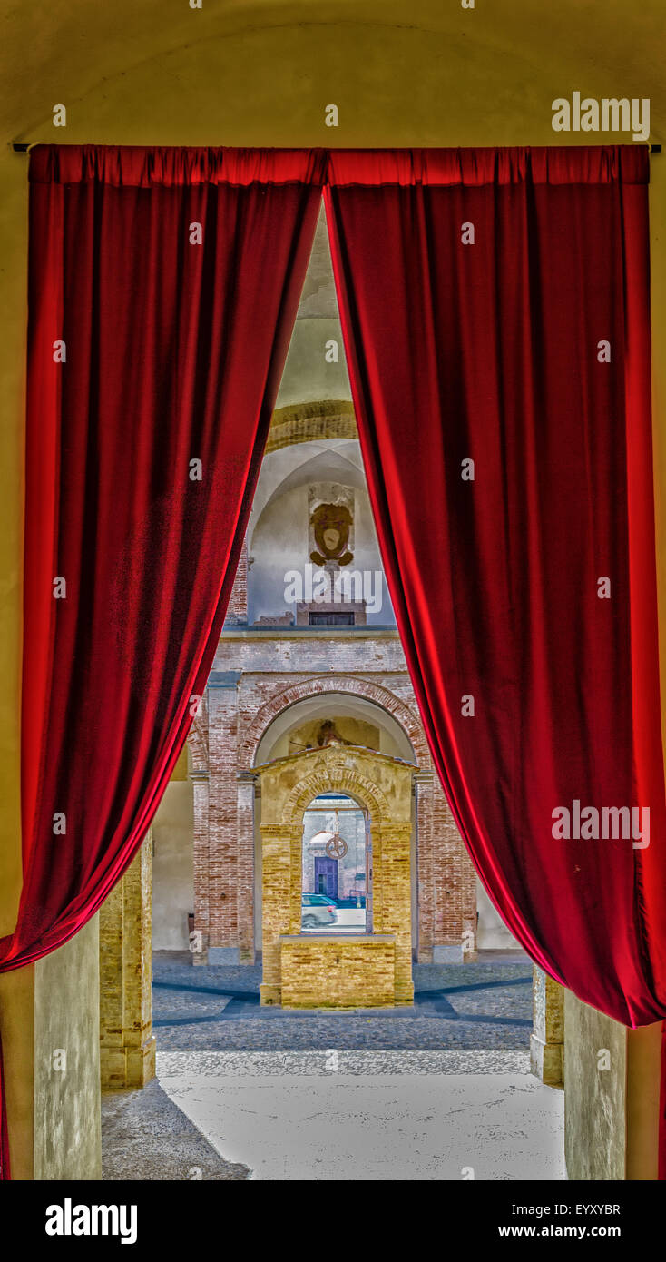 Il cortile con albero centrale del Pretore Palace rappresenta italiano architettura rinascimentale con elementi di pietra e mattoni ed è delimitato da triportico con due ordini dorico e ionico, colonne. Foto Stock