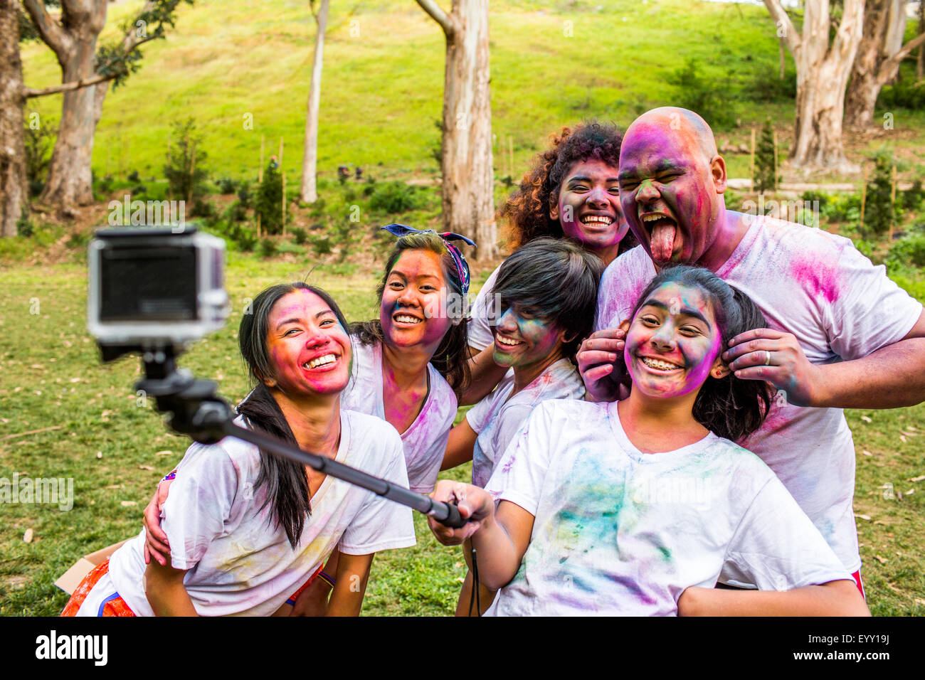 Amici coperto di pigmento in polvere utilizzando selfie stick Foto Stock