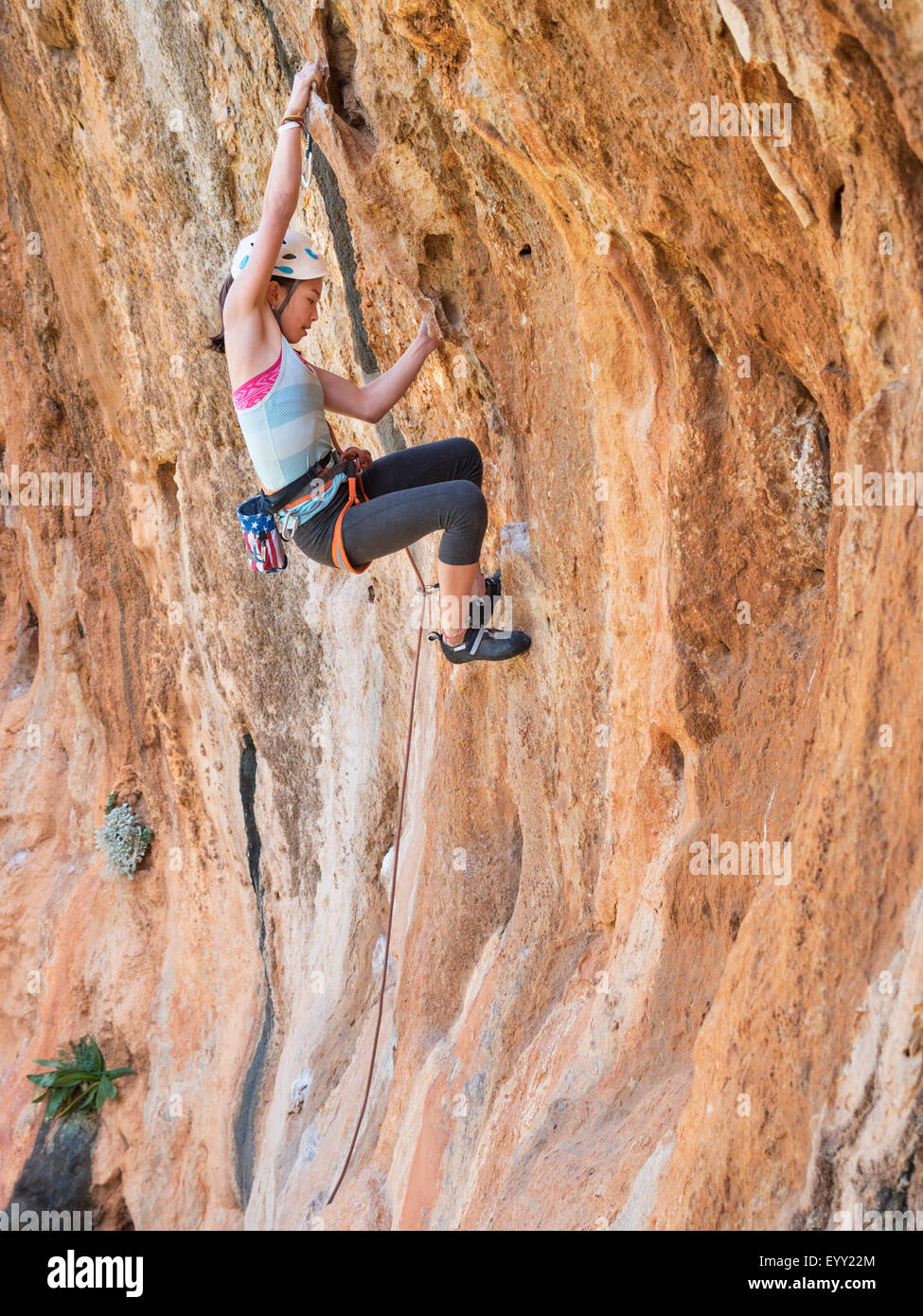 Razza mista ragazza arrampicata su parete di roccia Foto Stock