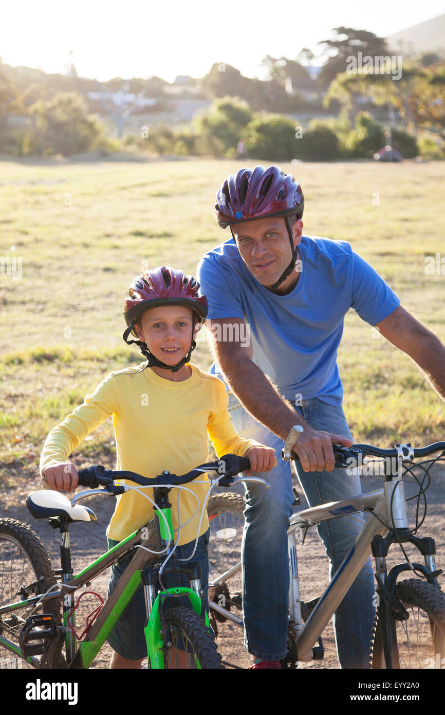 Caucasian padre e figlio di andare in bicicletta sul percorso di sporcizia Foto Stock