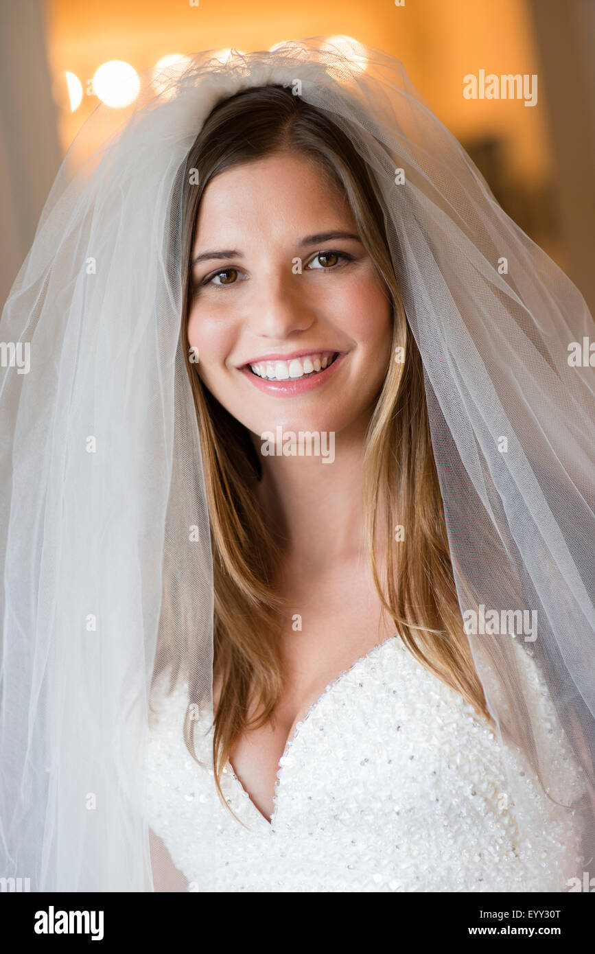 Sposa caucasica sorridente in abito da sposa e il velo Foto Stock