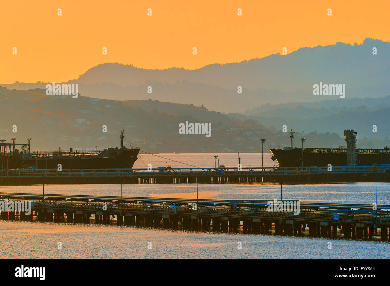 Silhouette di colline oltre il porto industriale di Porto Foto Stock