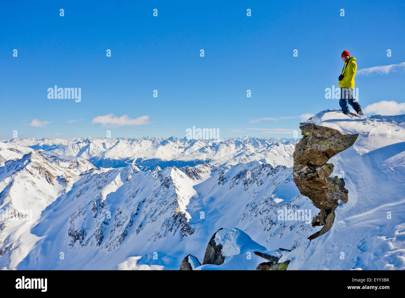 Escursionista ammirando vista panoramica dalla cima innevata Foto Stock