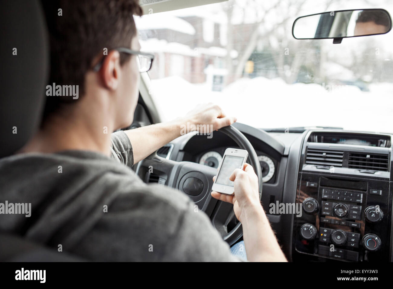 Uomo caucasico tramite telefono cellulare e la guida auto Foto Stock
