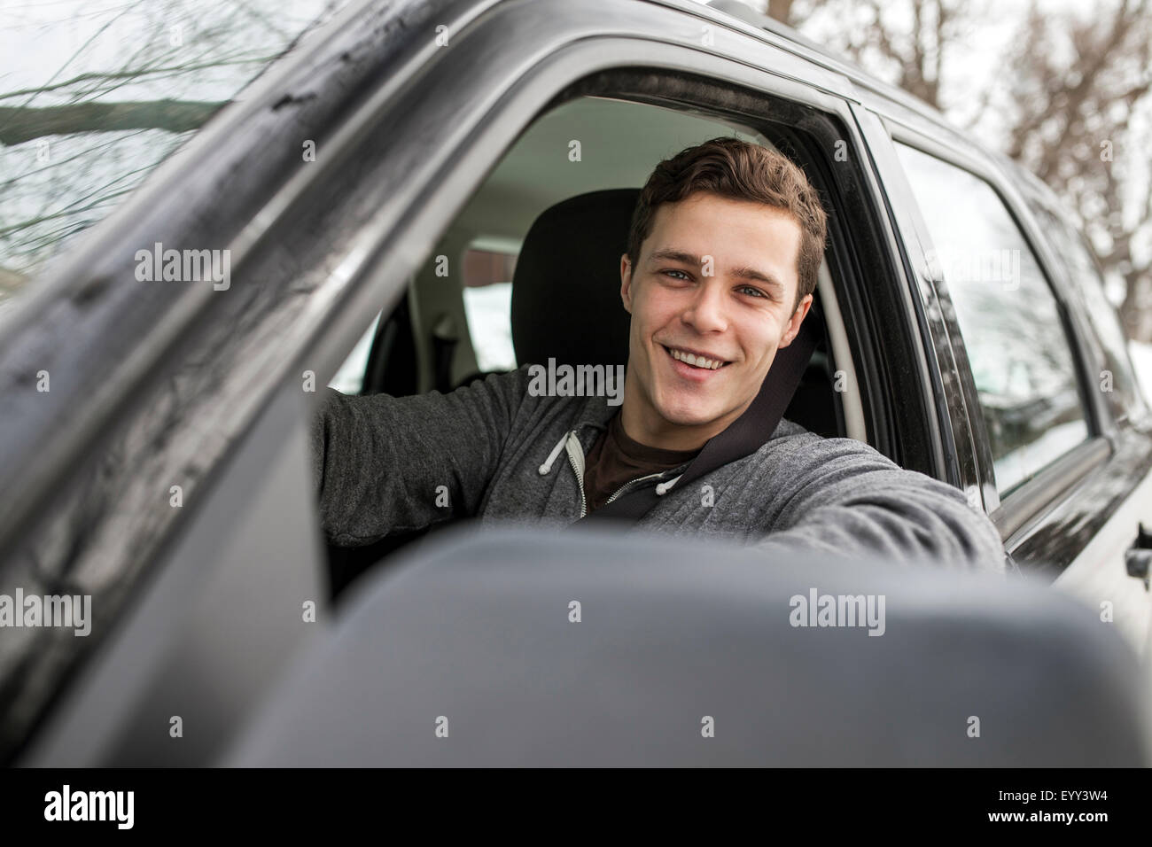 Uomo caucasico sorridente in vetro per auto Foto Stock