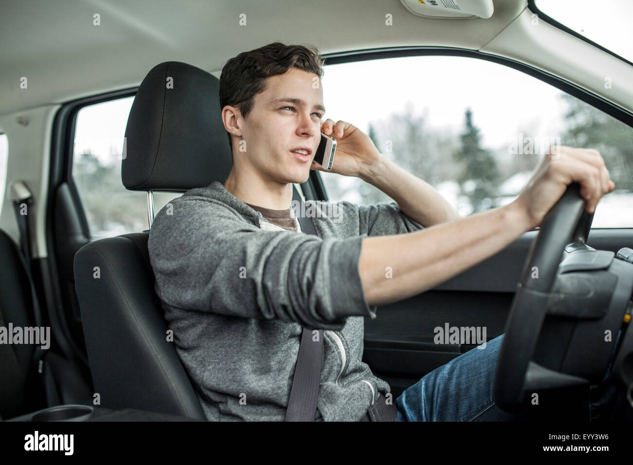 Uomo caucasico parlando al cellulare e auto di guida Foto Stock