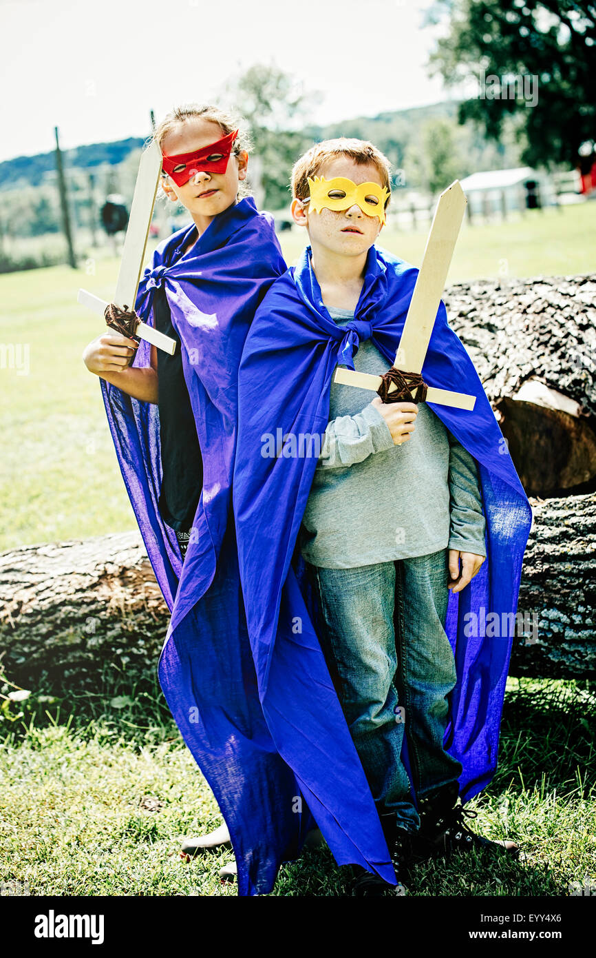 Bambini caucasici in costume a giocare con le spade Foto Stock